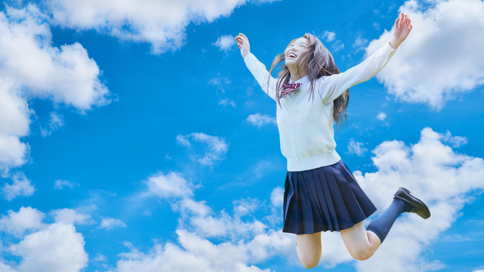 青空でジャンプする学生
